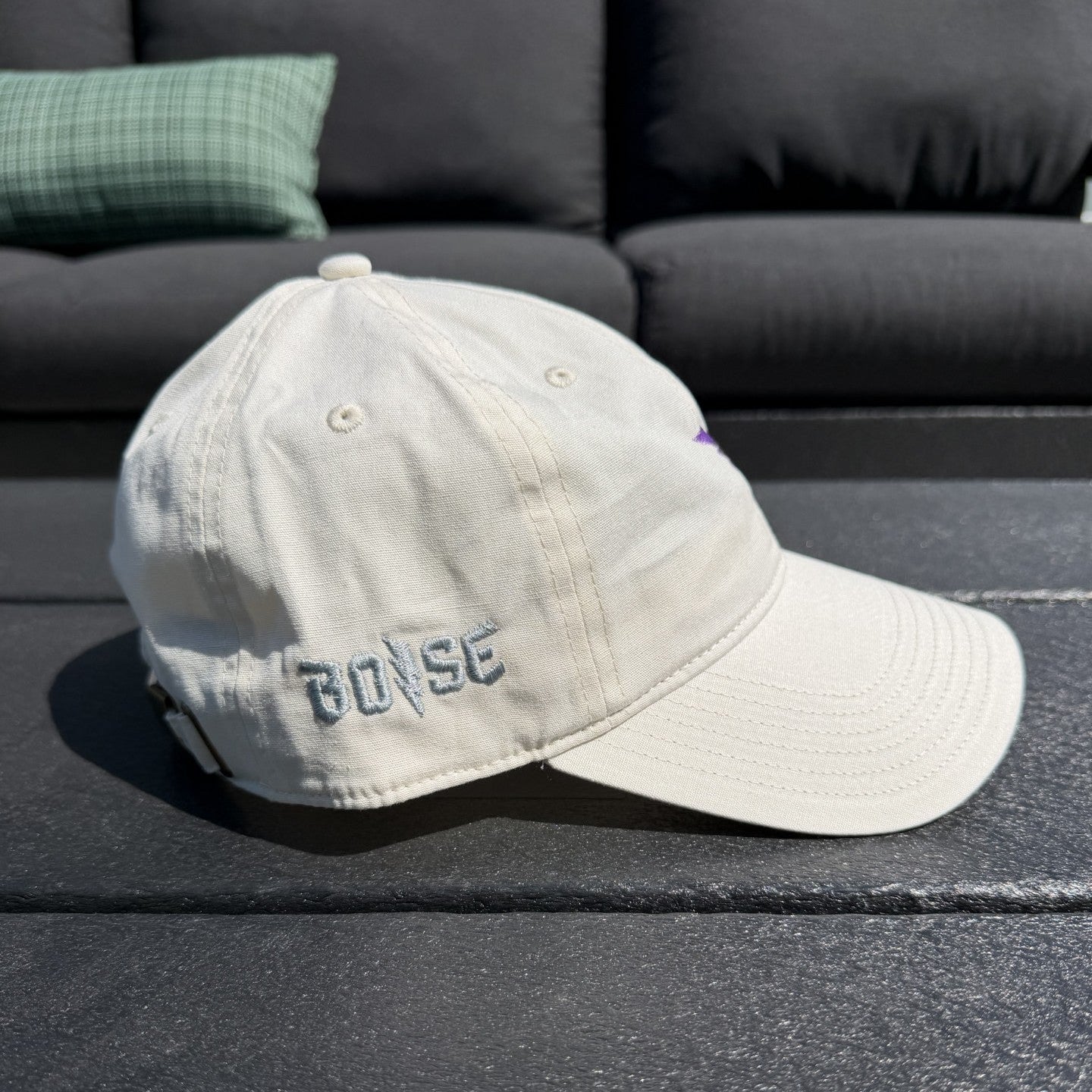 Beige cap with 'BOSE' logo on a dark surface