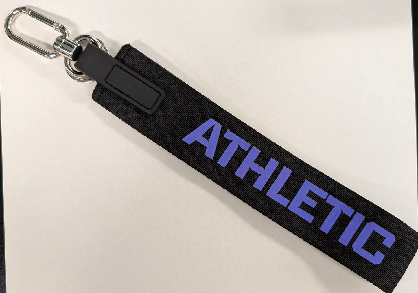 Black keychain with 'ATHLETIC' text on a white background