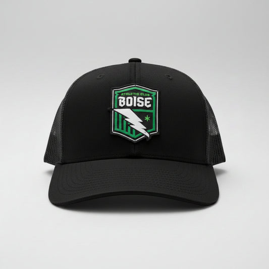 Black cap with a green and white logo on a dark surface
