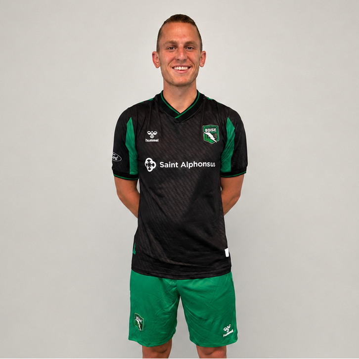 Person wearing a black and green sports outfit with visible branding on a gray background
