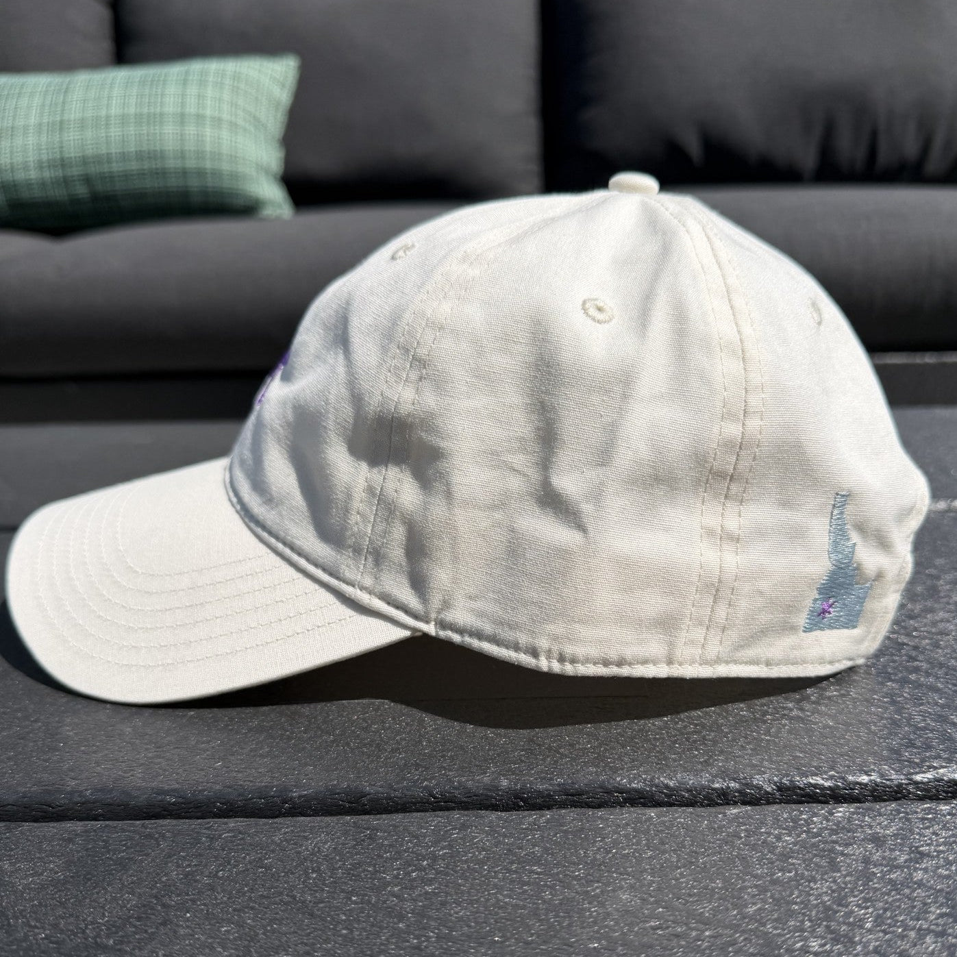 Beige cap with a logo on a dark surface